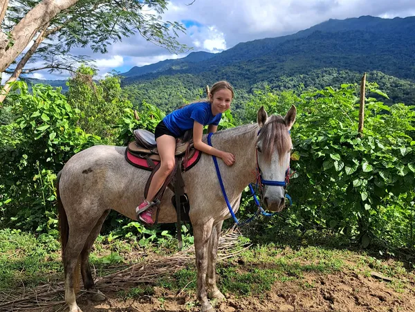 Young rider on horseback at Rainforest River Ride Adventure in El Yunque National Rainforest, Rio Grande, Puerto Rico